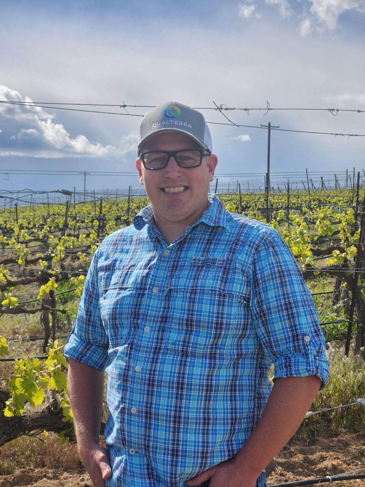 Qualterra Sales Executive, Cameron Fox stands in his family's vineyard near Benton City, Washington.